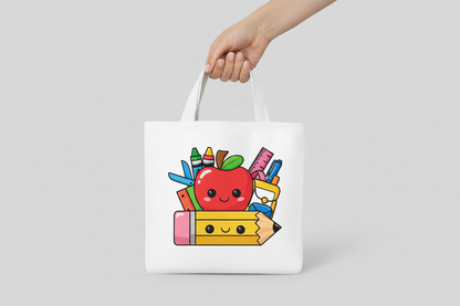 White tote bag with a black and white design of an apple and school supplies on a colorful background with stationery items.