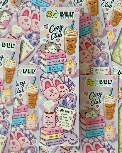 Several sheets of cute pastel sticker designs featuring a cozy bunny-themed aesthetic. The stickers include illustrations of a sleeping bunny on a stack of books, a coffee drink with a straw, candles, headphones, and hearts, with the text 'Cozy Club' and 'LULU DESIGNS'.