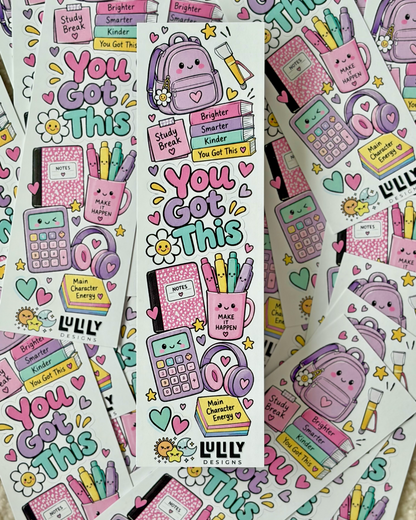 A sheet of cute school-themed stickers featuring the phrase 'You Got This' in colorful bubble letters, surrounded by illustrated backpacks, books, calculators, flowers, and motivational text. Multiple sheets are fanned out on a light beige textured surface.