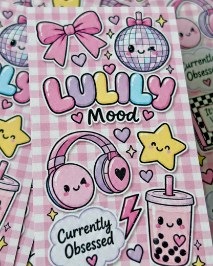 A close-up of a pink gingham sticker sheet featuring cute pastel cartoon graphics, including a disco ball, bow, headphones, stars, a boba cup, and the text 'LULILY Mood' and 'Currently Obsessed'.