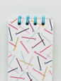 Notebook with colorful bobby pins pattern on a white background