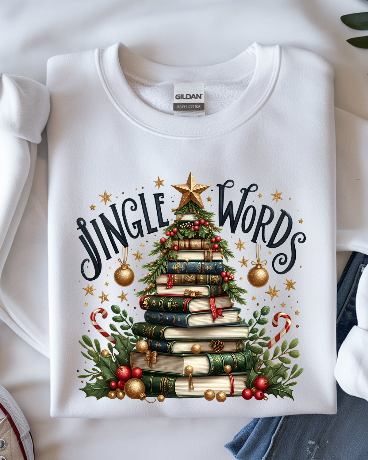 White sweatshirt with 'Jingle Words' design featuring a Christmas tree made of books on a white background.